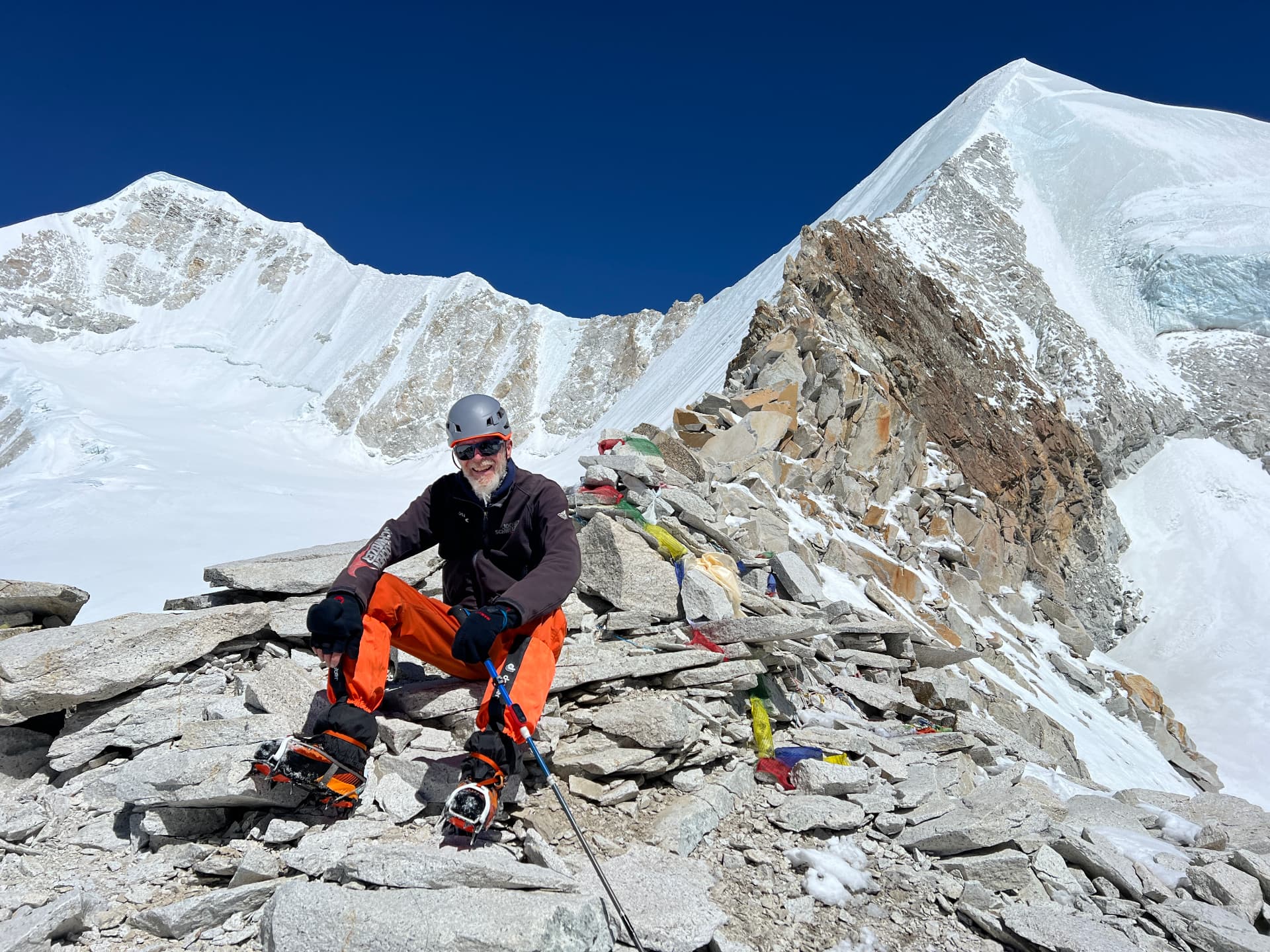 Marc assis sur une crête rocheuse de l'Himalaya, entouré de sommets enneigés
